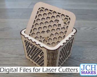 May include: A wooden box with a honeycomb pattern and two bees. The box is open and the lid is sitting on top of the box. The box is made for laser cutters.