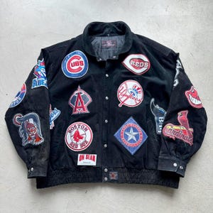 May include: A black leather jacket with various baseball team patches, including the Cubs, Red Sox, Yankees, Cardinals, and Texas Rangers. The jacket has a zipper closure and a ribbed waistband.