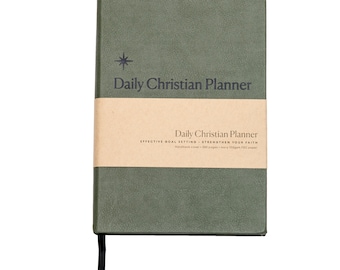 Puede incluir: Un planificador cristiano diario de tapa dura verde con una banda de papel marrón que dice "Daily Christian Planner, Effective Goal Setting - Strengthen Your Faith, Hardback cover - 200 pages - heavy 100gsm FSC paper".