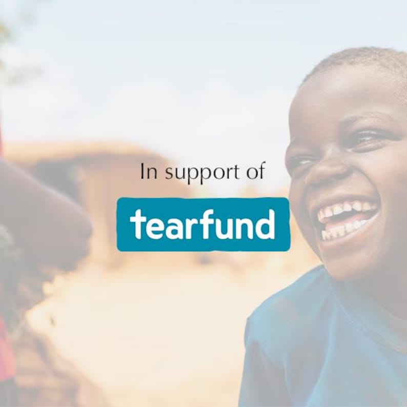 May include: A young person with a big smile, laughing, in support of Tearfund. The image is blurred and the background is out of focus.