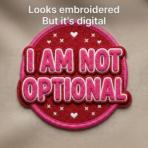 Può includere: Una toppa rotonda, rossa e rosa con la scritta "I AM NOT OPTIONAL" in rosa, bordata di bianco. La toppa ha un bordo cucito e piccoli cuori e croci bianche. Il testo "Looks embroidered But it's digital" è in alto.