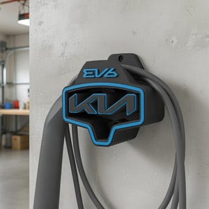 May include: Black and blue EV6 charger mount with the Kia logo, mounted on a light gray wall. The charger cable is gray and hangs down. The background shows a garage setting.