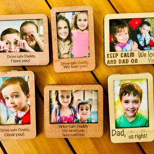 May include: Six wooden photo frames with different pictures of children and the text "Drive safe Daddy, I love you!"  "Drive safe Daddy, We love you!"  "Keep calm and Dad on, We love you!"  "Drive safe Daddy, We need you here with us!"  "Dad, you're steering us right!"