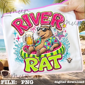 Peut inclure: Un t-shirt blanc avec un motif de capybara brun portant des lunettes de soleil et une chemise à fleurs, assis dans une bouée pastèque tout en tenant une chope de bière. Le texte RIVER RAT est imprimé en grandes lettres roses et vert citron.
