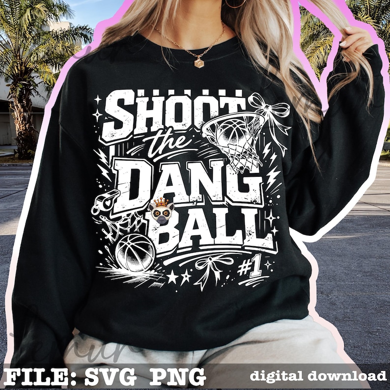 Puede incluir: Sudadera negra con un gr&aacute;fico blanco que dice "Shoot the Dang Ball" con una pelota de baloncesto, una red y estrellas. El dise&ntilde;o incluye un panda de dibujos animados con una corona. Tambi&eacute;n incluye el n&uacute;mero 1.