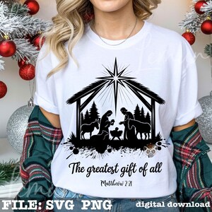 May include: White t-shirt featuring a black silhouette of the Nativity scene under a star. The text "The greatest gift of all" and "Matthew 2:21" are printed below the image. Digital download file.