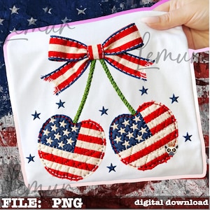 May include: A white fabric with an embroidered design featuring two heart-shaped cherries, each with a pattern of the American flag. A red, white, and blue bow sits above the cherries, connected by green stems. Blue stars are scattered around the design.
