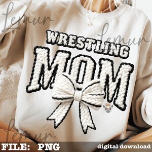May include: A white sweatshirt with the text "WRESTLING MOM" in a knitted style with black trim. A large knitted bow with black trim is centered below the text. The image also includes the text "FILE: PNG" and "digital download".