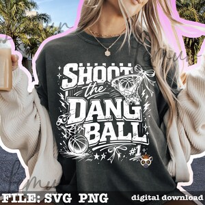 Puede incluir: Sudadera gris oscuro con el texto blanco "SHOOT the DANG BALL". El dise&ntilde;o incluye una pelota de baloncesto, una red, un silbato y estrellas. Tambi&eacute;n se incluye la frase "#1". Las palabras "FILE: SVG PNG" y "digital download" est&aacute;n en la parte inferior.