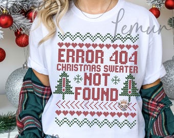 Könnte beinhalten: Weißes T-Shirt mit einem rot-grünen Weihnachtspullover-Design. Der Text lautet "ERROR 404 CHRISTMAS SWEATER NOT FOUND". Das Design umfasst Herzen, Weihnachtsbäume und Schneeflocken. Digitaler Download.
