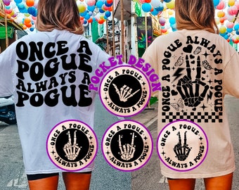 May include: Two people wearing white and beige t-shirts with a black graphic print that says "Once a Pogue Always a Pogue". The graphic includes a skeleton hand with a peace sign and lightning bolt. The shirts also feature a smaller circle graphic with a skeleton hand making a shaka sign.