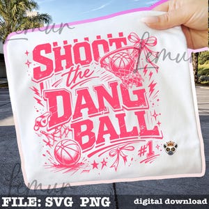 Puede incluir: Dise&ntilde;o gr&aacute;fico blanco con tem&aacute;tica de baloncesto con el texto "SHOOT the DANG BALL" en rosa. El dise&ntilde;o incluye una pelota de baloncesto, una red, un silbato y estrellas. Las palabras "FILE: SVG PNG" y "digital download" est&aacute;n en la parte inferior.