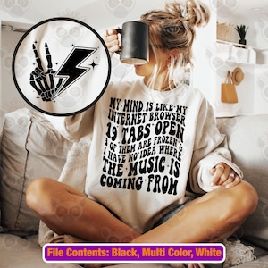 以下が含まれることがあります： 「My mind is like my internet browser 19 tabs open 3 of them are frozen & I have no idea where the music is coming from」という黒い文字が書かれた白いスウェットシャツ。
