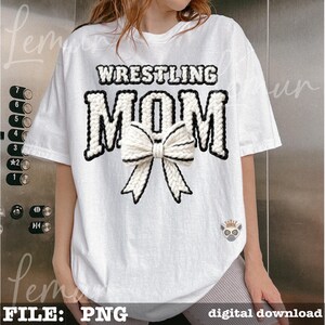 May include: White t-shirt with the text "WRESTLING MOM" in a black and white knitted design. A white bow with black trim is centered below the text. The shirt is a digital download.