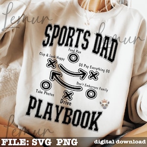 以下が含まれることがあります： クリーム色のスウェットシャツ。黒で「SPORTS DAD PLAYBOOK」の文字とプレイの図が描かれています。「Clap & Look Happy」、「Take Photos」、「Don't Embarrass Family」などのフレーズが含まれています。