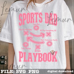 以下が含まれることがあります： 「SPORTS DAD PLAYBOOK」とピンク色のグラフィックがプリントされた白いTシャツ。デザインには「Food Run」、「Clap & Look Happy」、「Don't Embarrass Family」などのフレーズが含まれています。デジタルダウンロードです。