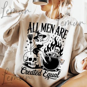 Può includere: Felpa color crema con grafica in bianco e nero. La grafica presenta una strega con una scopa, un teschio, uno scheletro in un calderone e il testo "ALL MEN ARE Created Equal".