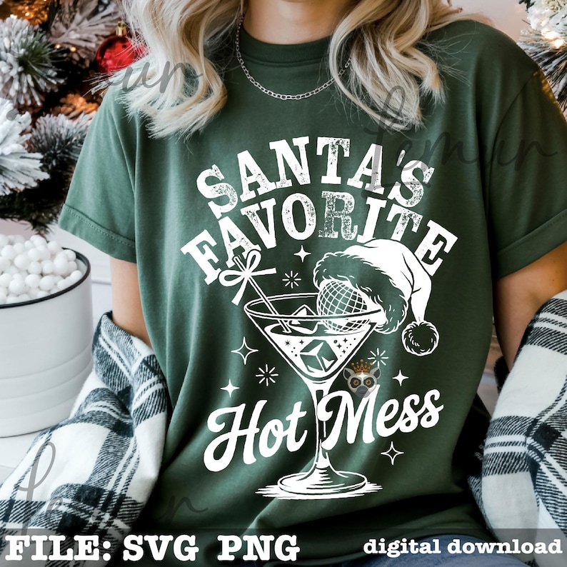 May include: Green t-shirt with a white graphic that reads "Santa's Favorite Hot Mess." The design includes a martini glass with a Santa hat, snowflakes, and stars. The words "FILE: SVG PNG" are at the bottom.