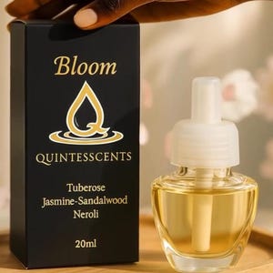 May include: A black box and a clear glass air freshener with a white top. The box reads "Bloom QUINTESSCENTS" with the scent notes: Tuberose, Jasmine-Sandalwood, Neroli. The air freshener contains 20ml of liquid.
