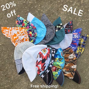 May include: A collection of twelve fabric welding caps featuring various patterns including orange and white logos, tropical floral prints, blue textures, black geometric shapes, solid teal, white, and horse prints, with text 20% off SALE.