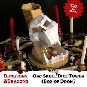 May include: A white papercraft Orc skull dice tower with a cardboard base and a cardboard tower on top. The skull is open and has a red dice inside. The tower is surrounded by candles, dice, and other decorative items. The text "ORC SKULL DICE TOWER (BOX OF DOOM)" is printed below the skull. The text "DUNGEONS & DRAGONS" is printed to the left of the skull. The text "PRINT ON PAPER!" is printed on a red starburst.