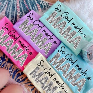 May include: Five t-shirts in different colors with the text "So God made a MAMA" in a gray animal print design.