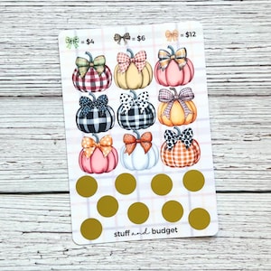 May include: A white sticker sheet featuring illustrated pumpkins with bows in various patterns and colors. The sheet includes gold scratch-off circles and the text "stuff and budget". The pumpkins are priced at $4, $6, and $12.