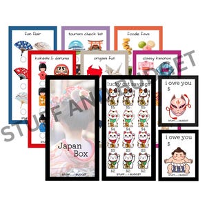 May include: A collection of colorful Japanese-themed prints, including "Fan Flair," "Tourism Check List," and "Lucky Cat Savings." The prints feature illustrations of fans, origami, and lucky cats. The text "Japan Box" is also visible.