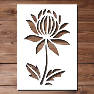 May include: White silhouette of a stylized flower with a large central bloom and leaves. The flower is cut out of a white sheet of paper.