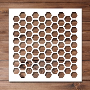 May include: White stencil featuring a honeycomb pattern. The stencil is made from a thin, flexible material and is designed for use with paint or other mediums.