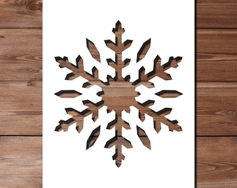 May include: A white paper snowflake cutout with a detailed design, against a brown wood background.