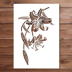 May include: A wooden lily flower stencil with detailed cut-out design. The stencil showcases a floral design with a natural wood grain pattern. The lily is depicted in a graceful style, suitable for crafting and decorative projects. The wood grain is visible.