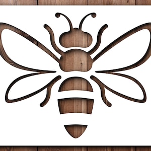 May include: A white bee silhouette stencil on a wood background. The bee has a simple design with wings, a body, and antennae.