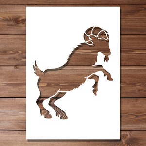 Könnte beinhalten: Eine weiße Silhouette einer Ziege mit gekräuselten Hörnern, die auf ihren Hinterbeinen auf einem Holzmaserungshintergrund steht.