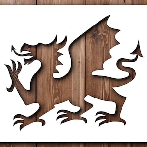 May include: A white stencil of a dragon, a traditional Welsh symbol, against a woodgrain background.