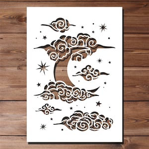 May include: White paper cut-out design of a crescent moon with swirling clouds and stars. The design is ideal for wall decor or a craft project.