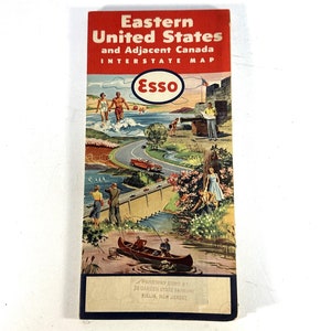 May include: A vintage Esso interstate map of the Eastern United States and adjacent Canada. The map cover features a colorful illustration of people enjoying outdoor activities, including swimming, fishing, and boating.