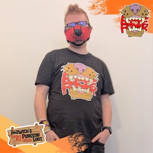 May include: A person wearing a red dog muzzle mask and a dark grey t-shirt with a cartoon dog face graphic that says "BEEF". The image also includes a logo that says "Dagwick's Total Dungeon Not Cursed Loot".