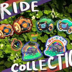 May include: A collection of six pride-themed keychains featuring a rainbow design and various characters. The keychains are made of clear acrylic with glitter accents. The text "PRIDE COLLECTION" is written in white on a rainbow background.