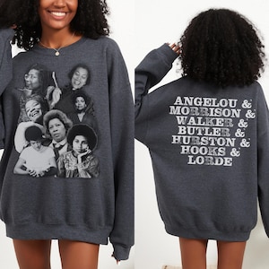 Puede incluir: Una sudadera gris oscuro con un collage de fotos en blanco y negro de mujeres en la parte delantera y el texto "ANGELO & MORRISON & WALKER & BUTLER & HURSTON & HOOKS & LORDE" en la parte posterior.