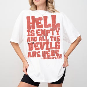 May include: White t-shirt with the quote "Hell is empty and all the devils are here" in red block letters. The quote includes a small devil graphic and is attributed to Shakespeare.