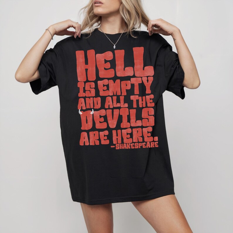 May include: Black t-shirt with the quote "HELL IS EMPTY AND ALL THE DEVILS ARE HERE." in red block letters. The quote is attributed to Shakespeare. The shirt is a casual, oversized style.