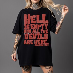 May include: Black t-shirt with the quote "HELL IS EMPTY AND ALL THE DEVILS ARE HERE." in red block letters, attributed to Shakespeare. The shirt is a casual, oversized style.