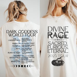 Puede incluir: Camiseta color crema con la inscripción "DARK GODDESS WORLD TOUR" en la espalda, que enumera lugares y artistas de la gira. La parte delantera muestra "DIVINE RAGE" con "SACRED. FURIOUS. ETERNAL. 2025 TOUR" y una ilustración de serpiente.