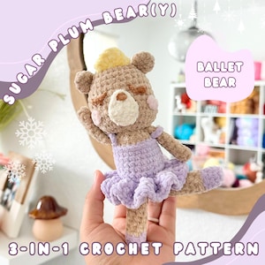 Könnte beinhalten: Ein gehäkelter Ballettbär, der ein lila Tutu und eine gelbe Krone trägt. Der Bär wird von einer Hand gehalten. Das Bild enthält den Text "SUGAR PLUM BEAR(Y)" und "BALLET BEAR".