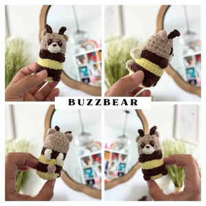 Puede incluir: Un juguete de peluche tejido a crochet con temática de abeja con rayas marrones y amarillas. El juguete tiene una carita pequeña con ojos negros y una nariz marrón. El juguete está siendo sostenido en una mano.