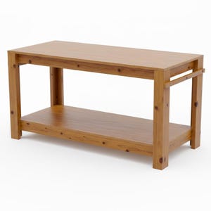 May include: A rectangular wooden coffee table with a lower shelf. The table is constructed from light brown wood and features a simple, sturdy design. The table's dimensions are approximately 48 inches long, 24 inches wide, and 18 inches high.
