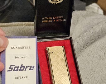 Encendedor de butano Sabre vintage de los años 40, tono dorado, en su caja original con papeles - Hermoso metal grabado en tono dorado