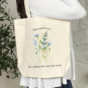 Pode incluir: Uma bolsa tote de lona branca com um design floral e o texto "This above all: To thine own self be true".