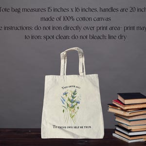 Pode incluir: Uma bolsa tote branca com um design floral e o texto "This above all: To thine own self be true". A bolsa &eacute; feita de lona de algod&atilde;o 100% e mede 38 cm por 41 cm. As al&ccedil;as medem 51 cm de comprimento.